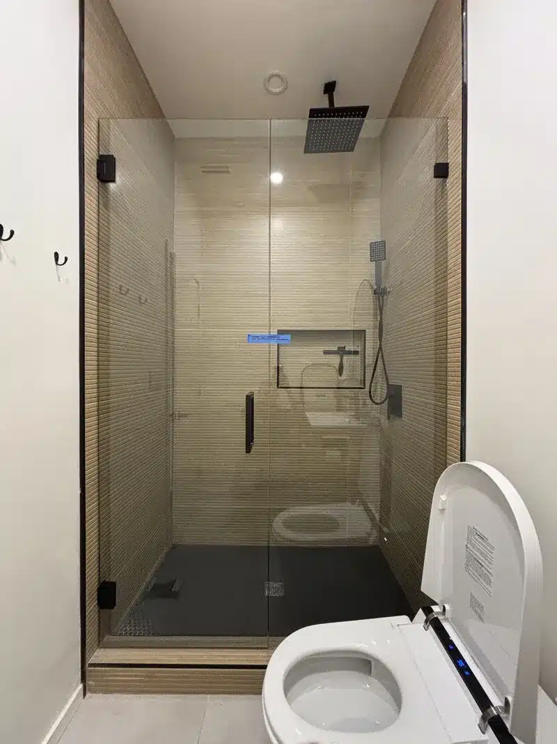 Compact in-and-out swinging frameless door and inline panel in San Clemente