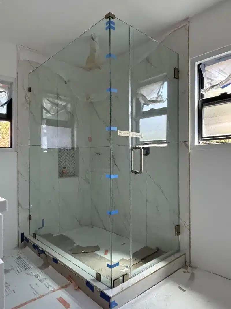 209-pound brushed-bronze corner panel in a completed San Clemente frameless shower enclosure