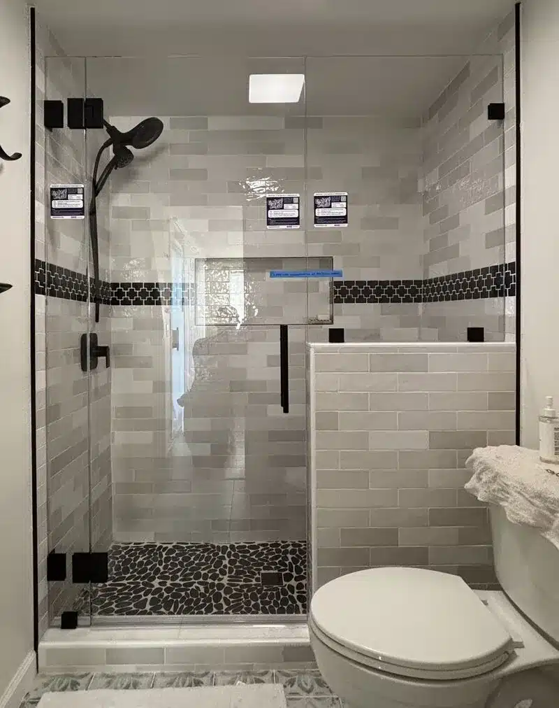 Optiwhite low-iron frameless shower enclosure with half-inch support panel on a pony wall in San Clemente